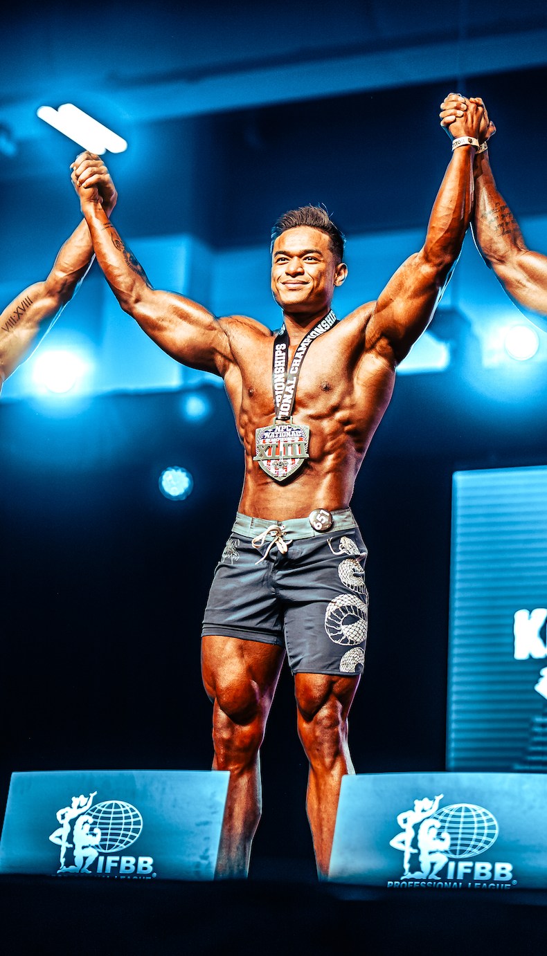 Francis Rances, IFBB Pro and founder of Aesthetic Dream, celebrating on a bodybuilding competition stage